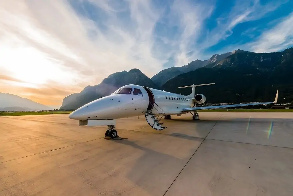 Sky N Jet Private jet Legacy 600 parked on the airport apron with stunning mountain sunset in the backdrop - luxurious travel at its finest