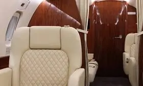 The picture highlights The interior of the Legacy 600 private jet which is a testament to its sleek and elegant design, with beautiful veneers and plush seats that exude sophistication.