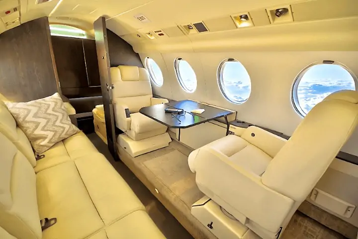DASSAULT FALCON 50's cabin is a haven of comfort with plush seats, sleek veneers, and modern amenities, in addition to wide windows that let natural light flood in