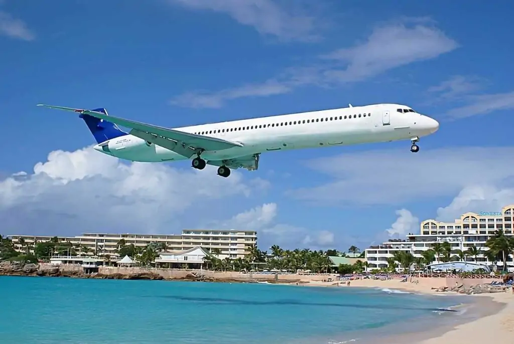 Mcdonnell Douglas DC 9-33 of Sky N Jet flies high above a stunning beach with crystal-clear blue waters and buildings