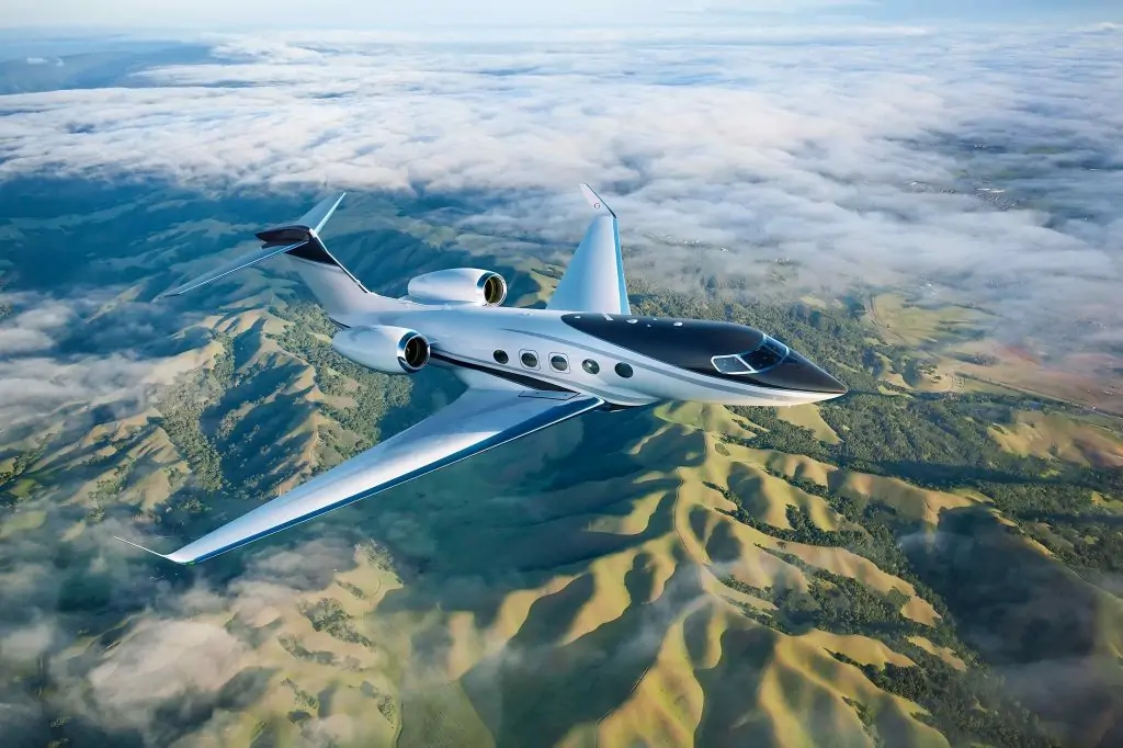 gulfstream g450 soaring abiove amazing mountains covered by green