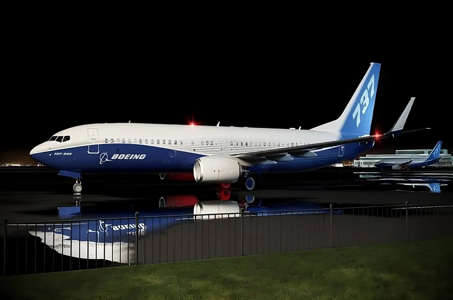 a Boeing 737-800 is parked on the apron, illuminated by the night's soft glow. Its striking blue colors shimmer under the sky