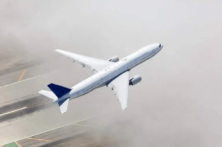 Boeing 777 aircraft commences its journey, lifting off the runway with its landing gear gracefully retracting