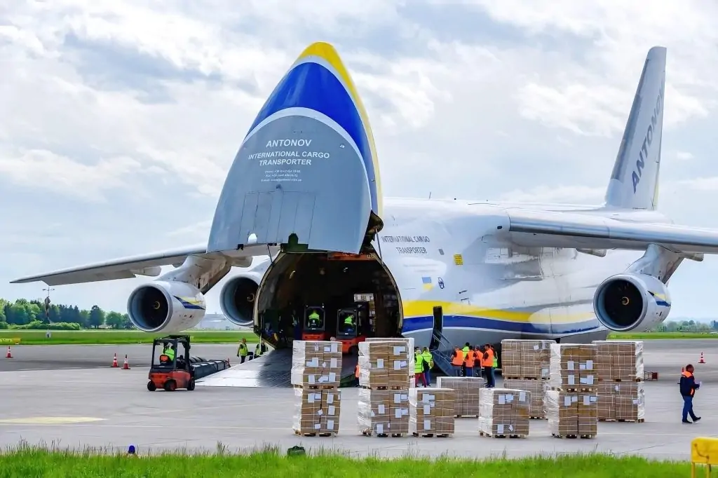 A captivating visual capturing the essence of cargo aircraft charter, featuring the impressive sight of Antonov 124 freighters lined up on the apron. Dedicated workers diligently load cargo into these massive aircraft